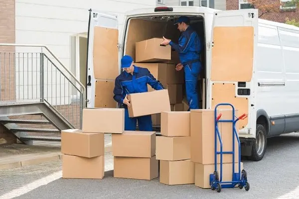 Profesionales empacando muebles con materiales especializados